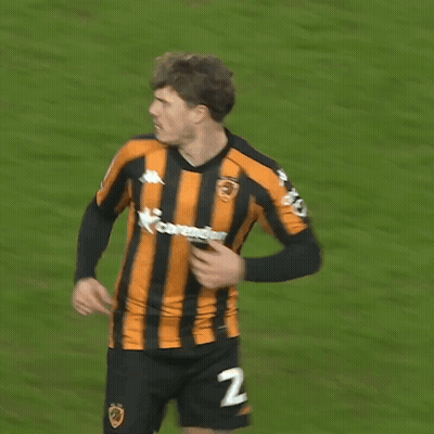 a soccer player wearing a black and orange striped jersey with the number 27 on the back
