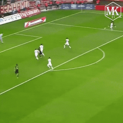 A Soccer Player Wearing A Black And Yellow Jersey Is Running On The Field GIF