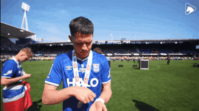 A Soccer Player Wearing A Blue Halo Shirt Looks At His Watch GIF