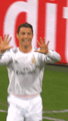 A Soccer Player Wearing A Fly Emirates Jersey Is Waving His Hands GIF