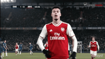 A Soccer Player Wearing A Fly Emirates Jersey Stands In Front Of A Crowd GIF