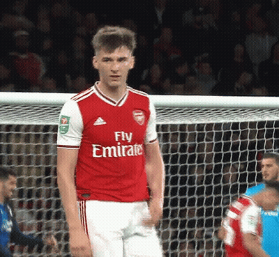 A Soccer Player Wearing A Fly Emirates Jersey Stands In Front Of A Net GIF