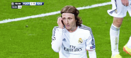 A Soccer Player Wearing A Fly Emirates Jersey Wipes His Face With His Hand GIF