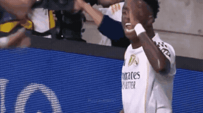 A Soccer Player Wearing A Fly Emirates Shirt Is Giving A High Five To His Teammates . GIF