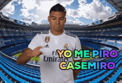 A Soccer Player Wearing A Fly Emirates Shirt Stands In Front Of A Stadium GIF
