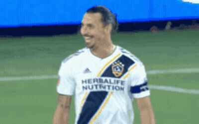 A Soccer Player Wearing A Herbalife Nutrition Jersey Smiles GIF