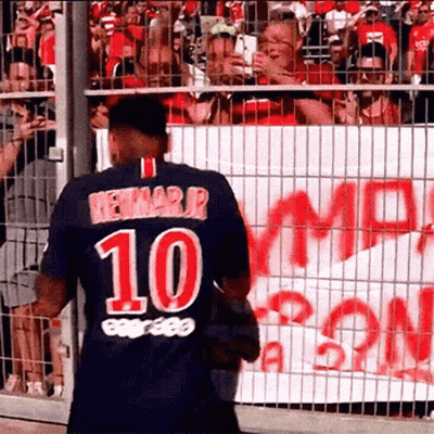A Soccer Player Wearing A Jersey With The Number 10 On It Is Standing In Front Of A Crowd Of People . GIF