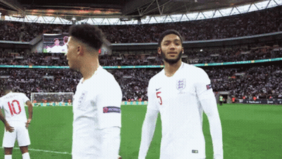 A Soccer Player Wearing A Number 5 Jersey Stands Next To Another Player Wearing A Number 10 Jersey GIF