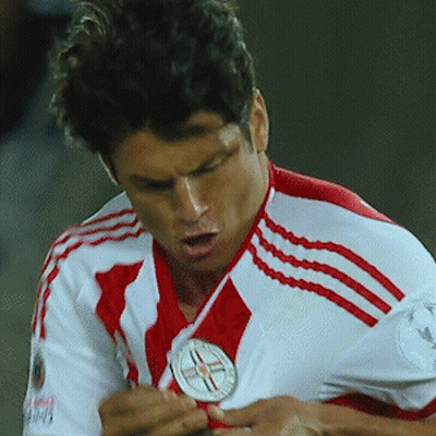 A Soccer Player Wearing A Red And White Jersey Is Holding A Medal GIF