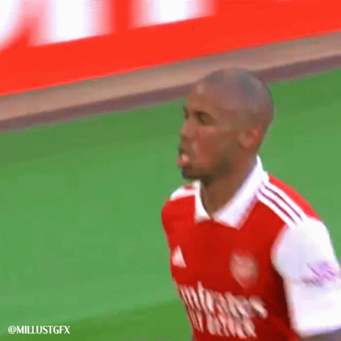 A Soccer Player Wearing A Red And White Jersey Is Standing On A Field . GIF