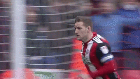 A Soccer Player Wearing A Red And White Jersey With Adidas On The Back GIF