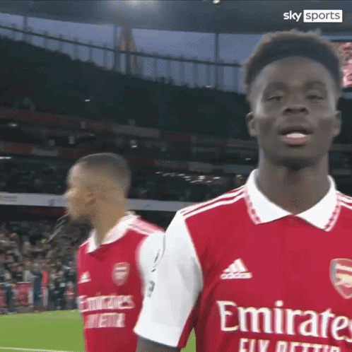 A Soccer Player Wearing A Red Emirates Jersey Stands On The Field GIF