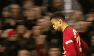 A Soccer Player Wearing A Red Jersey With The Number 21 On It Is Walking In Front Of A Crowd . GIF
