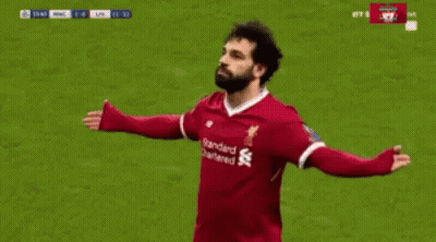 A Soccer Player Wearing A Red Jersey With The Word Standard Chartered On It Is Celebrating A Goal . GIF