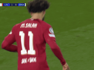 A Soccer Player Wearing A Red Shirt That Says Standard Chartered Is Pointing Up GIF
