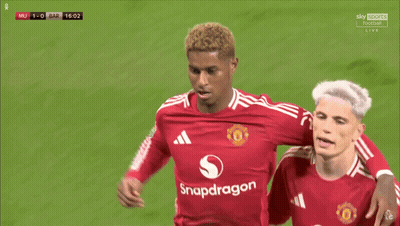 A Soccer Player Wearing A Red Snapdragon Jersey Holds His Finger To His Ear GIF