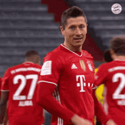 A Soccer Player Wearing A Red T-Mobile Jersey Is Standing In Front Of His Teammates . GIF