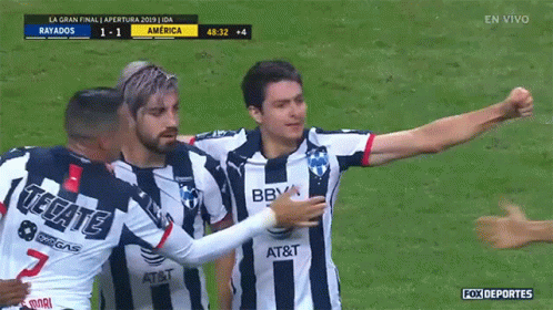 A Soccer Player Wearing A Tecate Jersey Is Hugging Another Player On The Field GIF