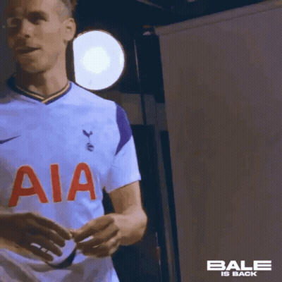 A Soccer Player Wearing A White Jersey With Aia On The Front Is Standing In Front Of A Light . GIF