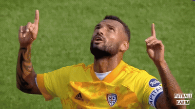 A Soccer Player Wearing A Yellow Adidas Jersey Points Up GIF
