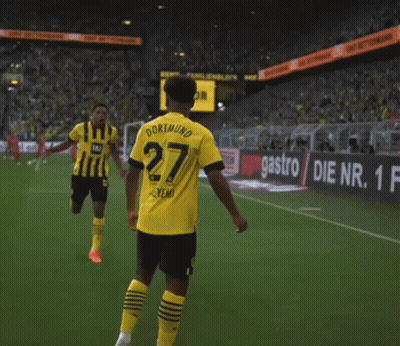 A Soccer Player Wearing A Yellow And Black Jersey With The Number 27 On It GIF