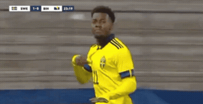 A Soccer Player Wearing A Yellow Jersey With The Number 11 On It Is Standing In Front Of A Stadium . GIF