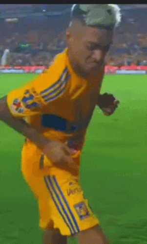 A Soccer Player Wearing A Yellow Jersey With The Number 18 On The Back GIF