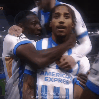 A Soccer Player Wearing An American Express Jersey Is Being Hugged By His Teammates GIF