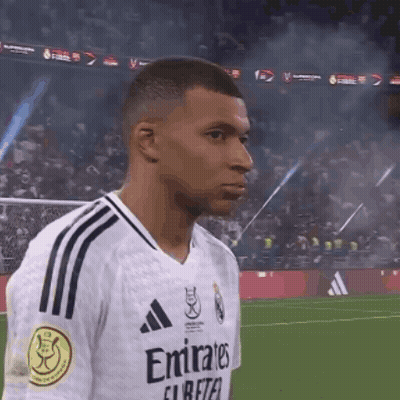 A Soccer Player Wearing An Emirates Jersey Is Standing On The Field GIF