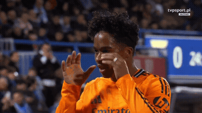 A Soccer Player Wearing An Orange Jersey With Emirates On It GIF