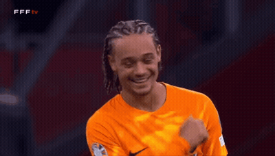 A Soccer Player Wearing An Orange Nike Jersey Is Smiling And Laughing GIF