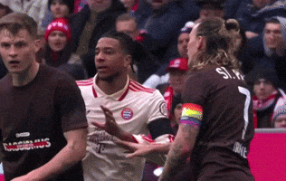 A Soccer Player With A Rainbow Armband Is Being Tackled By Another Player GIF