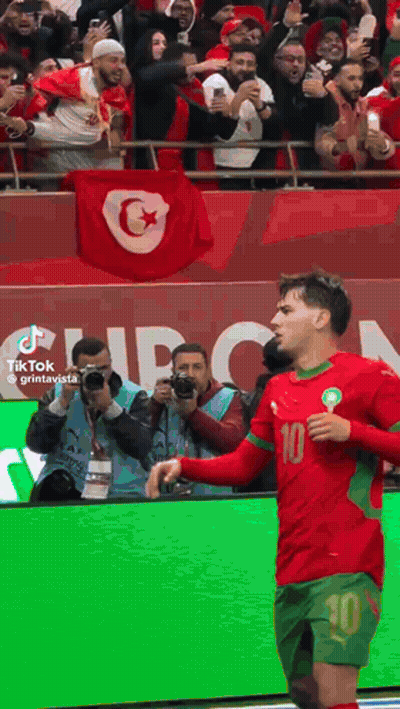 A Soccer Player With The Number 10 On His Jersey Stands In Front Of A Crowd GIF