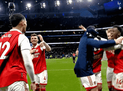 A Soccer Player With The Number 12 On His Jersey Is Surrounded By His Teammates GIF