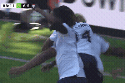 A Soccer Player With The Number 14 On His Back Is Hugging Another Player GIF