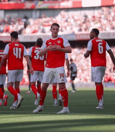 A Soccer Player With The Number 14 On His Shorts Stands On The Field With Other Players GIF