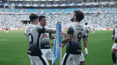 A Soccer Player With The Number 19 On His Back Is Hugging Another Player GIF