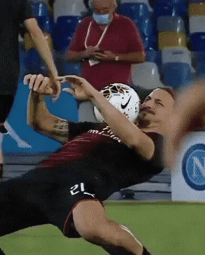 A Soccer Player With The Number 21 On His Shorts Is Falling To The Ground GIF