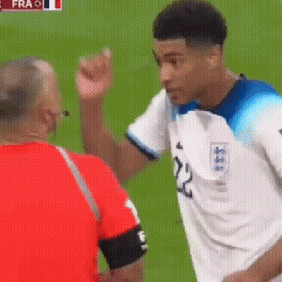 A Soccer Player With The Number 22 On His Jersey Is Talking To A Referee On The Field . GIF