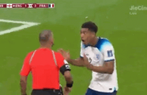 A Soccer Player With The Number 22 On His Jersey Stands In Front Of A Referee GIF