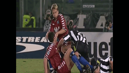 A Soccer Player With The Number 23 On His Back Is Being Tackled By Another Player GIF