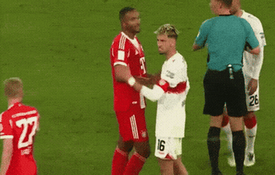 A Soccer Player With The Number 26 On His Shorts Is Kissing Another Player On The Cheek GIF