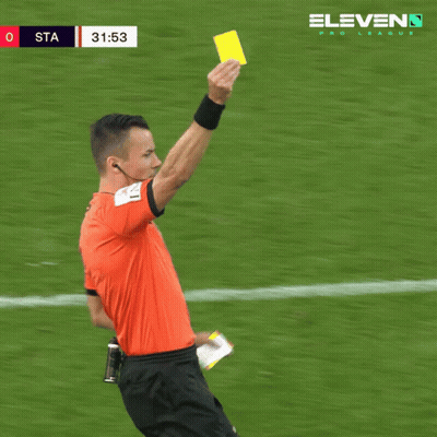 A Soccer Referee Holds Up A Yellow Card In Front Of A Eleven Pro League Banner GIF