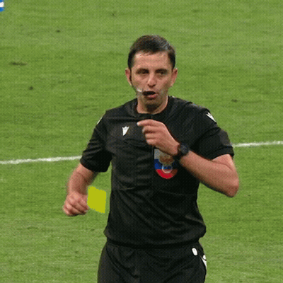 A Soccer Referee Holds Up A Yellow Card With A Crown On It GIF