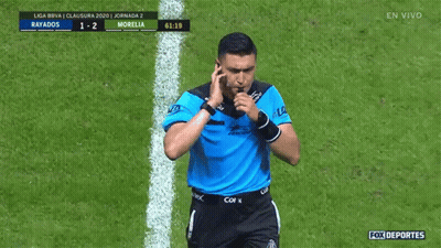 A Soccer Referee Is Pointing At A Scoreboard That Says Rayados 1-2 Morelia GIF