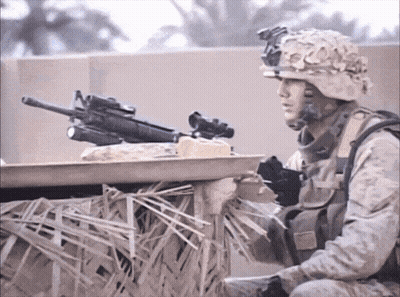 A Soldier In A Helmet Holds A Gun In His Right Hand GIF