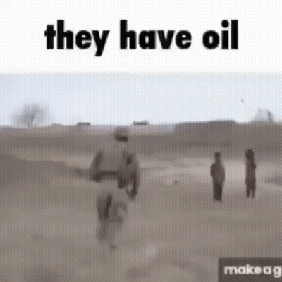 A Soldier Is Walking Through A Dirt Field With A Group Of Children . GIF