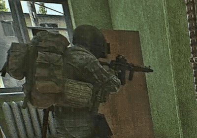 A Soldier With A Backpack Is Holding A Gun In A Room GIF