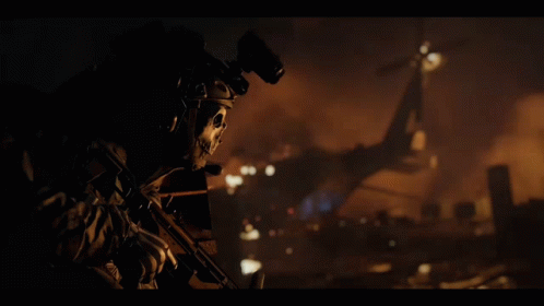 A Soldier With A Skull Mask On His Face Holds A Gun GIF
