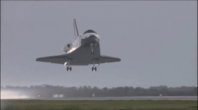A Space Shuttle Taking Off From A Runway With Nasa On The Side GIF